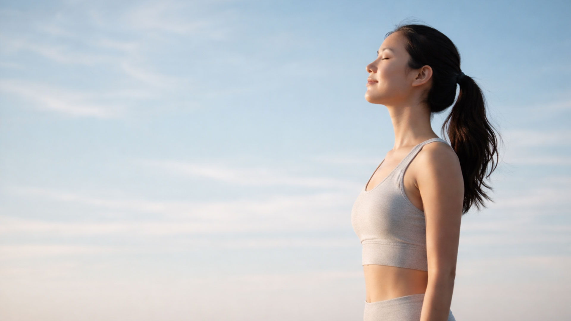 Woman breathing peacefully against a clear sky